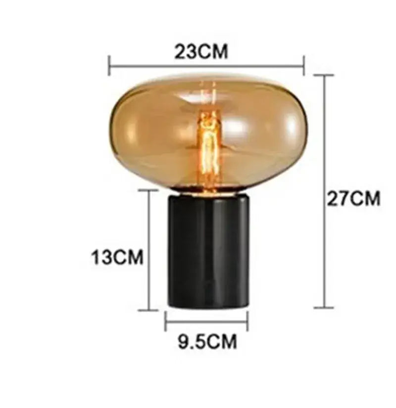 A sleek decorbites amber glass table lamp with a black cylindrical base and warm amber glass for modern living spaces
