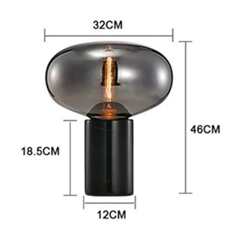 A sleek black base supports a translucent smoked glass lampshade with an exposed bulb in the decorbites amber glass table lamp
