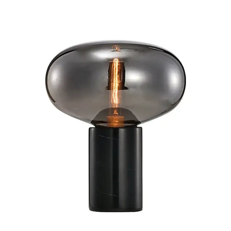 Decorbites amber glass table lamp featuring a smoked glass globe with exposed filament bulb on black marble base