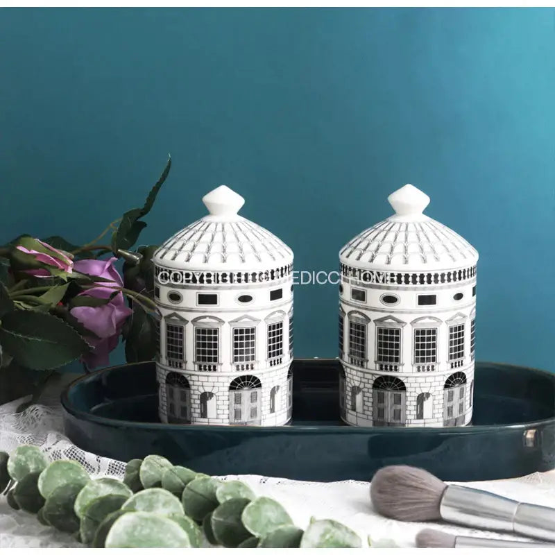 Pair of white ceramic candle holders with black domed tops designed in ancient roman architecture style by DecorBites