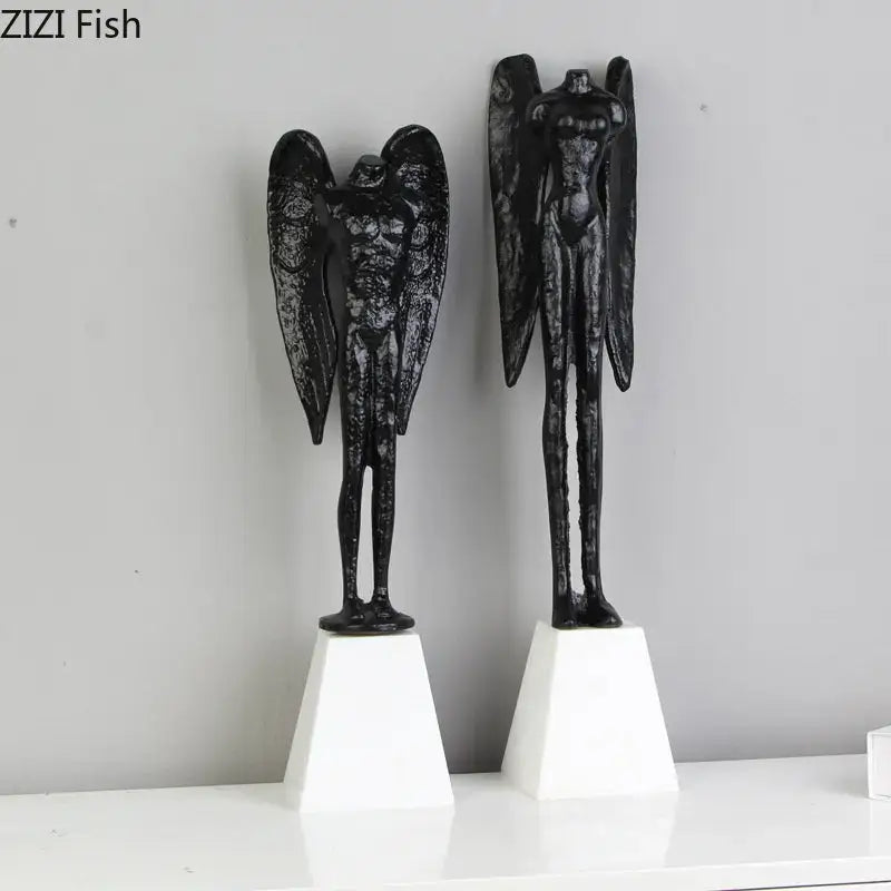 Black angel abstract figures sculpture cast iron with textured wings on white pedestals for home decor by DecorBites
