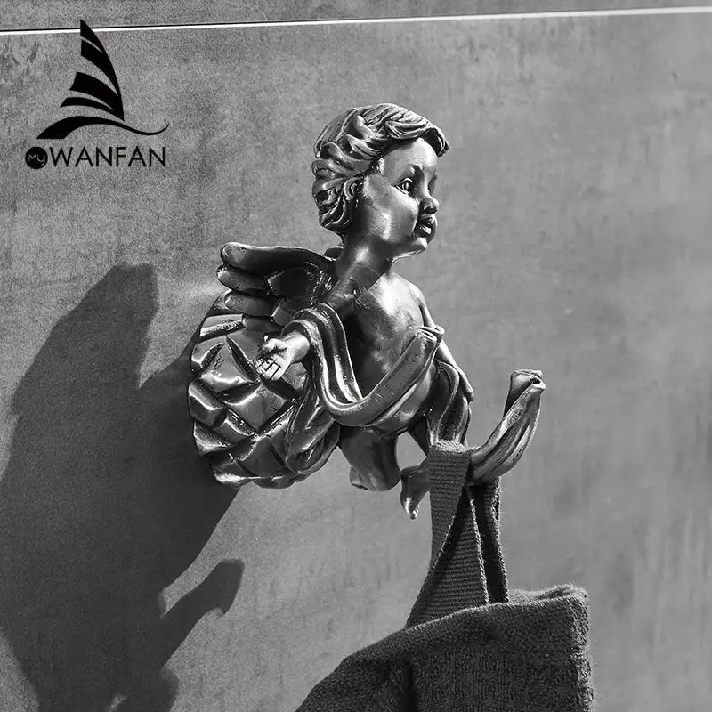 Bronze-colored angel brass towel hook with detailed wings and draped fabric for wall-mounted towel hanging