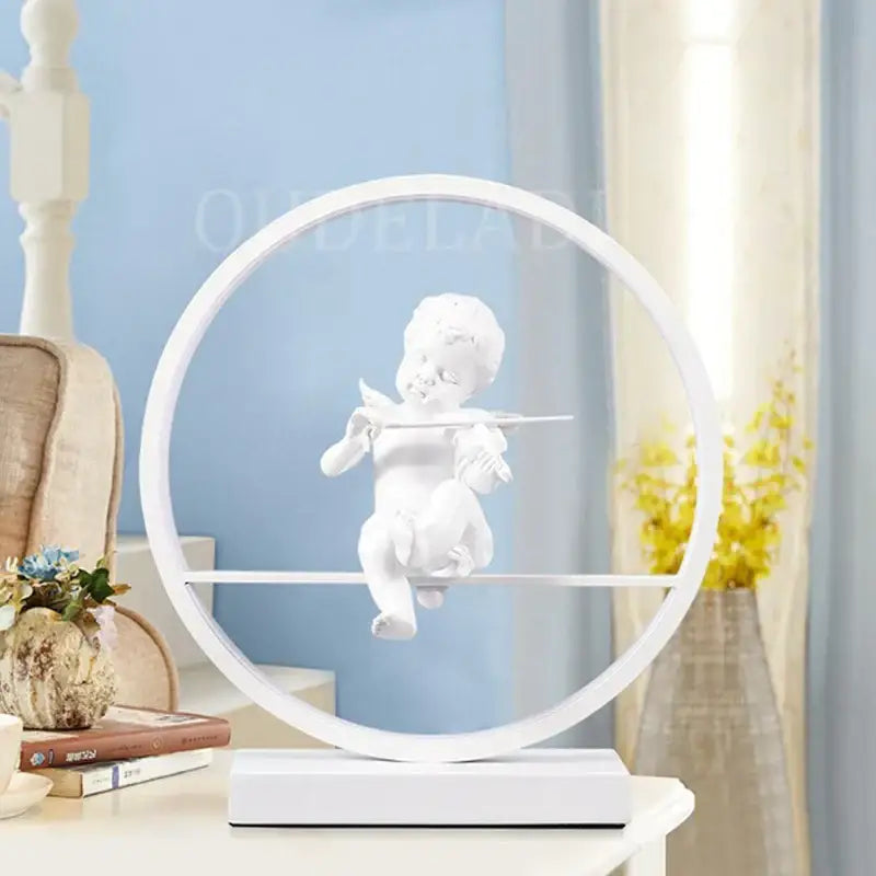White ceramic cherub figurine suspended in a minimalist circular frame on the decorbites angel doll bird table lamp
