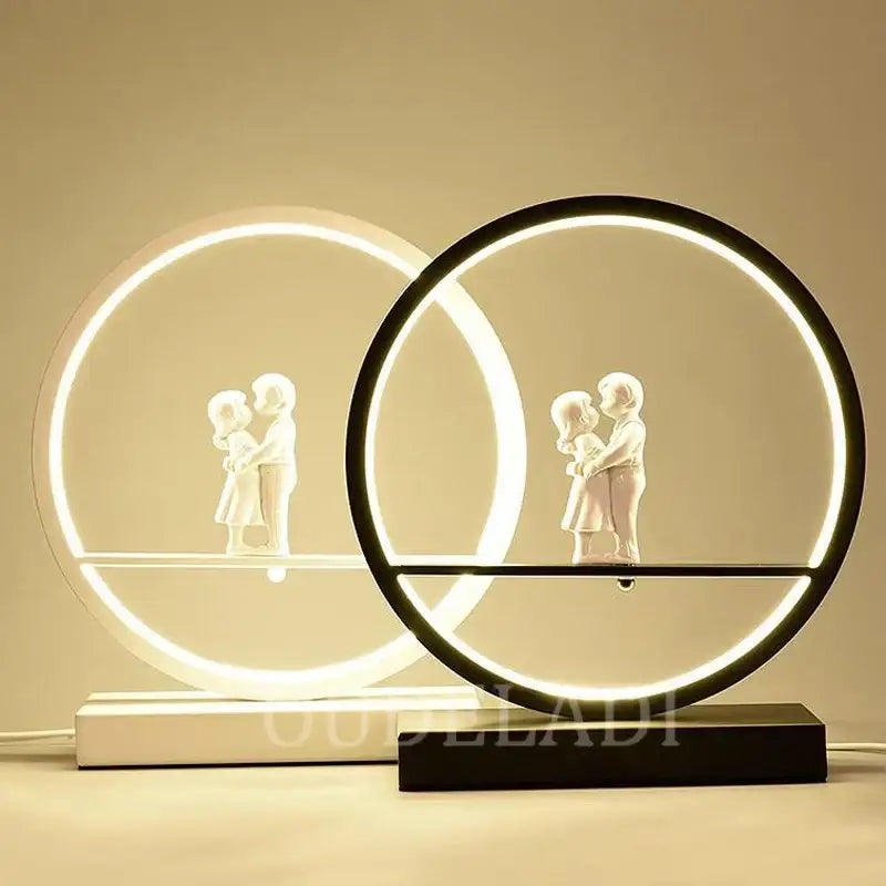 Modern circular led table lamp with illuminated rings and white angel doll bird figurines on minimalist bases