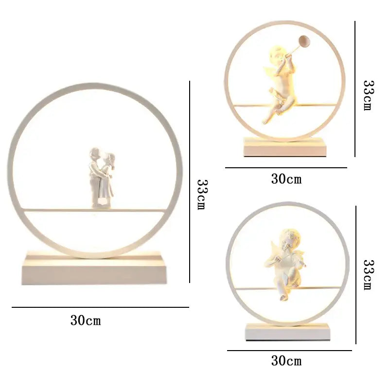 White resin angel doll bird table lamp featuring a couple kissing with integrated LED lighting in a circular frame
