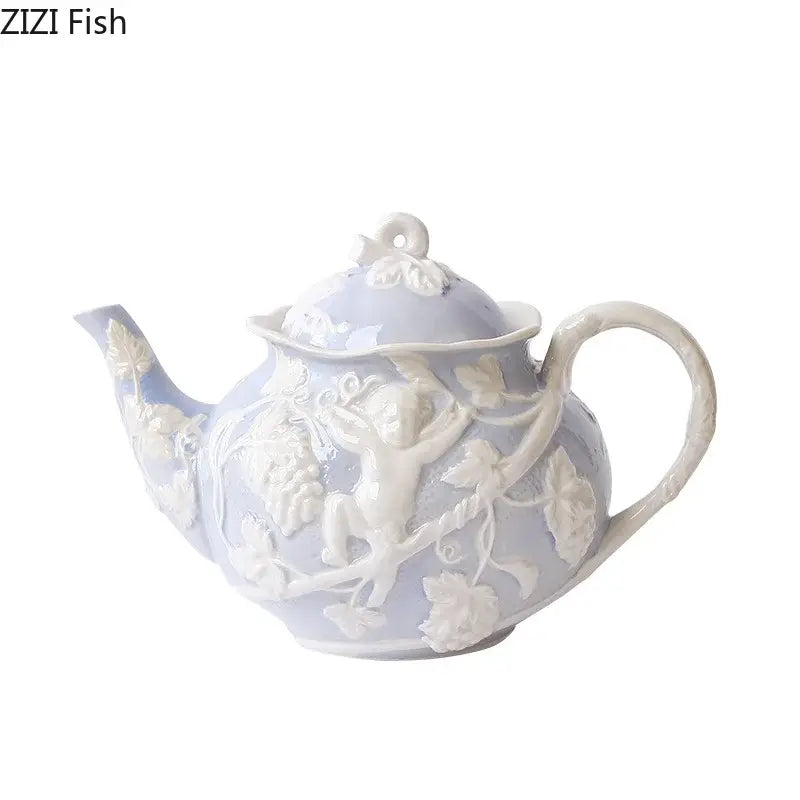 A delicate lavender ceramic teapot with intricate white angel figures relief of cherubs and grapevines from decorbites