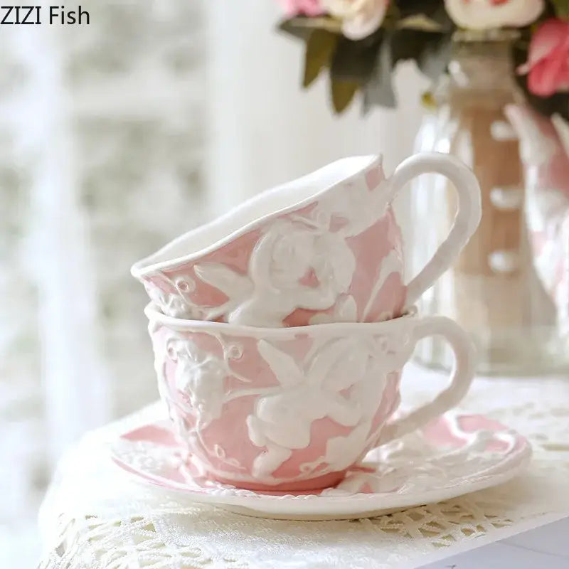 Pink ceramic teacup with white angel figures relief design stacked on matching saucer from decorbites ceramic dining set