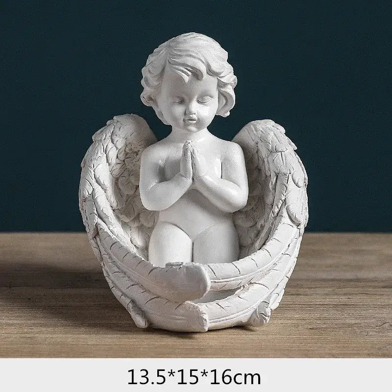 White angel girl resin figurine with detailed feathered wings and clasped hands seated on a sculpted base for decor