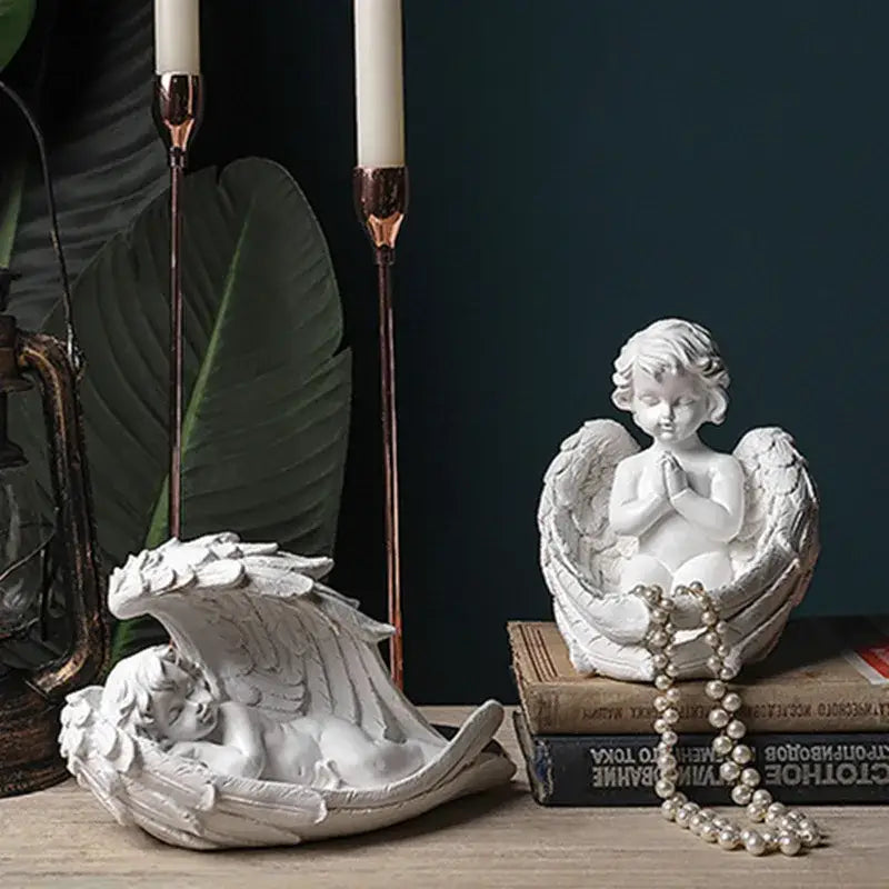 White angel girl resin figurine with detailed wings and clasped hands seated in sculpted wing cradle for decor and gifts