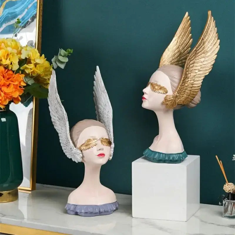 Decorbites™ angel girl statue featuring two busts with golden eye masks, white and gold wings, and ruffled collars in lavender and teal