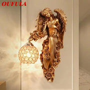 Golden angel indoor wall light led in gold resin with intricate wing and rose design and spherical crystal globe shade