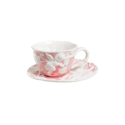 Pink ceramic teacup with white angel relief ceramic design paired with matching saucer from DecorBites relief ceramic tableware set
