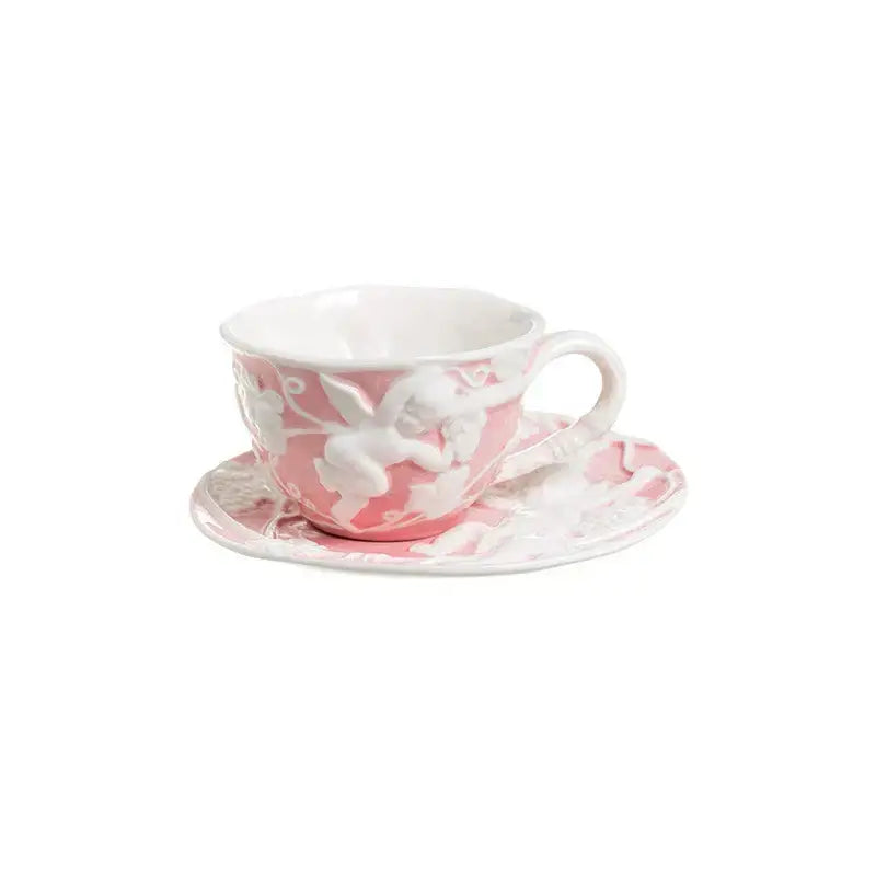 Pink ceramic teacup with white angel relief ceramic design paired with matching saucer from DecorBites relief ceramic tableware set