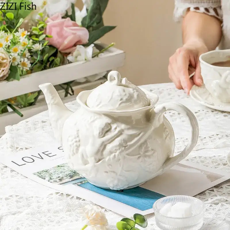 White ceramic teapot with intricate floral design from decorbites angel relief ceramic tableware set