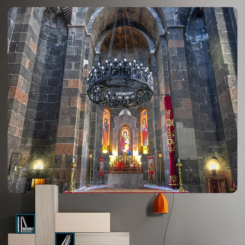 Ornate black wrought iron chandelier with candle bulbs hanging above altar in stone church complements boho wall decor