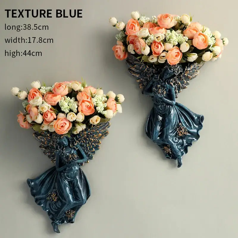Deep blue resin DecorBites angel vase wall decoration with ornate wings holding peach and white roses for living room