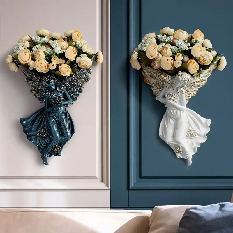 Two decorative wall-mounted angel vase wall decorations in dark teal resin and white ceramic holding rose bouquets