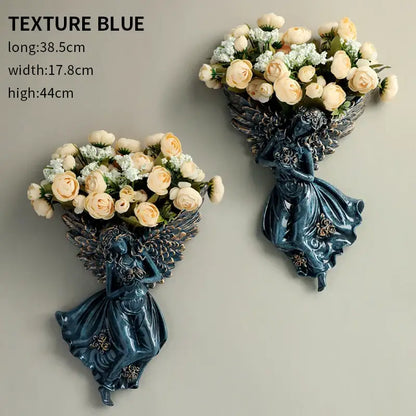 Deep teal resin DecorBites angel vase wall decoration with intricate wings holding cream roses for living room use