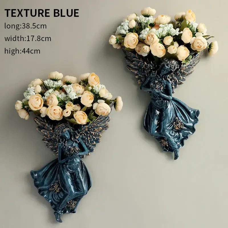 Deep teal resin DecorBites angel vase wall decoration with intricate wings holding cream roses for living room use