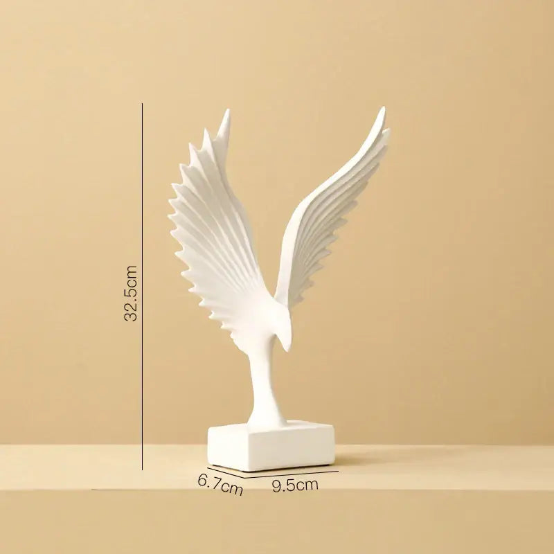 White ceramic angel wings sculpture with detailed outstretched wings on a sleek base by DecorBites™