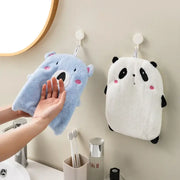 Blue plush bear-shaped bath sponge with pink cheeks hanging beside a white panda animal hand towel from decorbites hand towels set