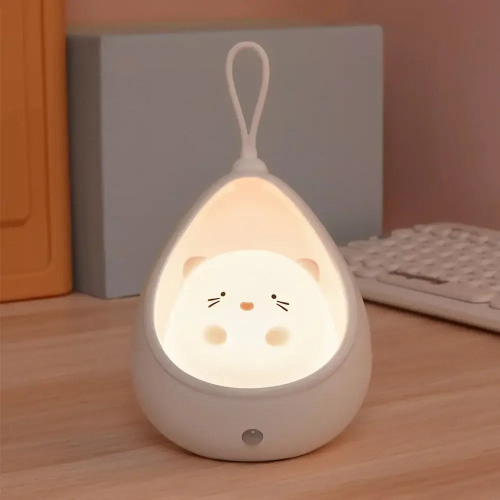 A soft white silicone decorbites™ animal night light shaped like a teardrop with a cute hamster face and usb rechargeable design