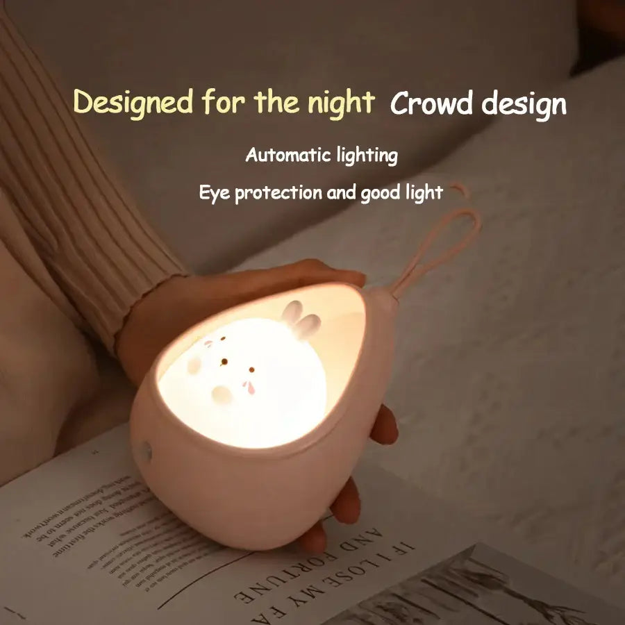 Soft pink egg-shaped silicone animal night light with bunny face design and sensor control for kids by decorbites