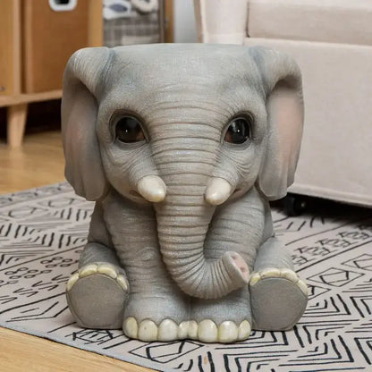 Gray resin baby elephant figurine with oversized ears glossy black eyes and ivory tusks as a resin sculpture footstool seat
