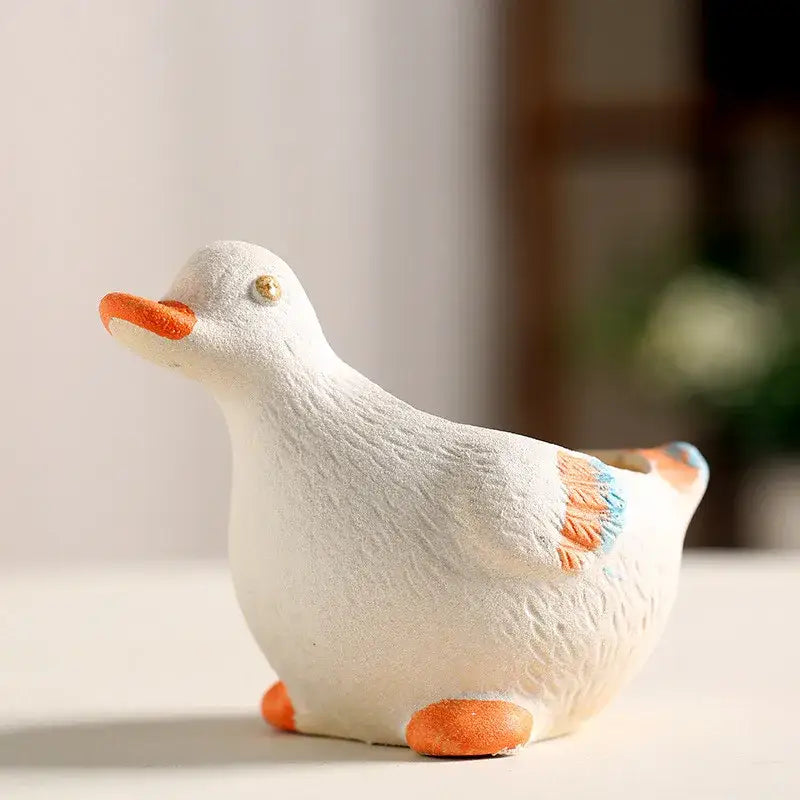 White ceramic animal vase succulent shaped like a duck with orange beak feet and wing accents for garden decor