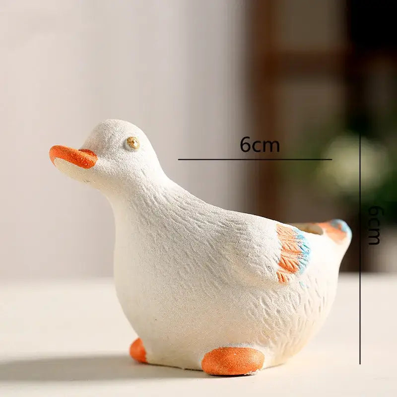 White ceramic animal vase succulent pot with orange accents shaped like a duck for garden decor by DecorBites