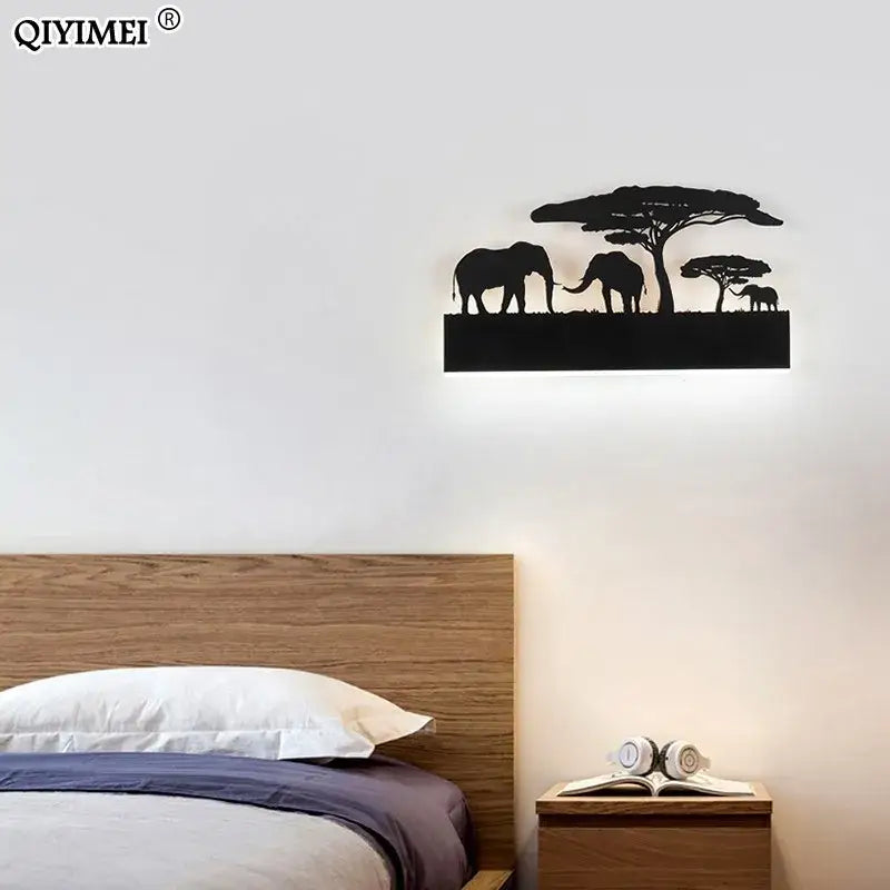 Black metal animal wall lamps featuring elephant and acacia tree silhouettes with warm upside and cool down lighting