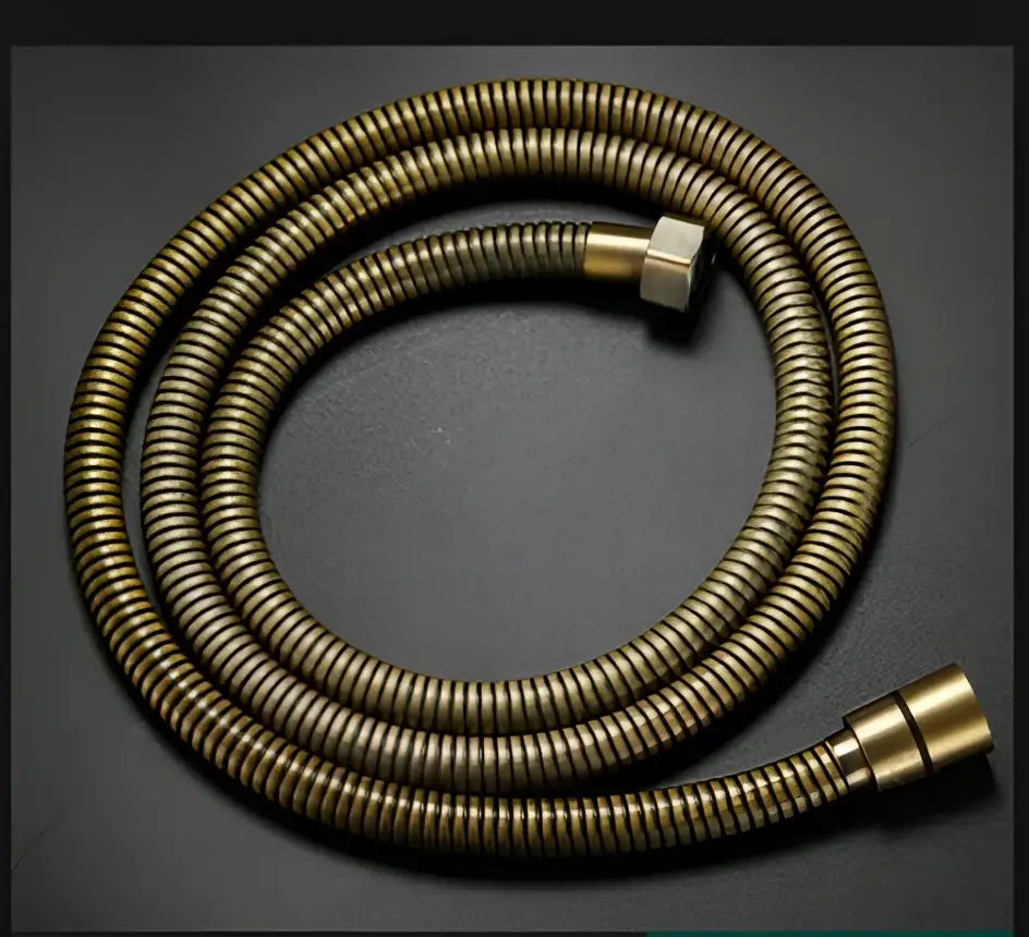 A coiled brass-colored flexible shower hose with metallic connectors for decorbites antique bathroom handheld shower head