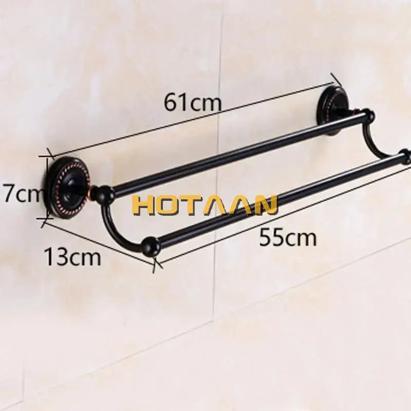 Black double towel bar by decorbites with ornate circular wall mounts and curved ends in antique brass finish