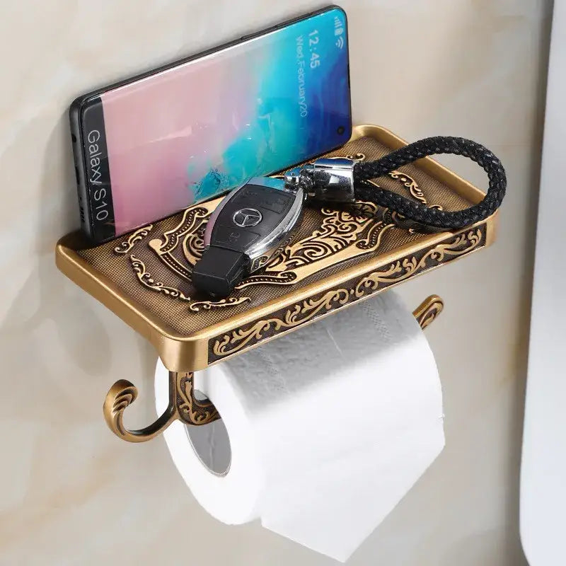 Antique black brass toilet paper holder with ornate scrollwork shelf holding smartphone and key fob by decorbites