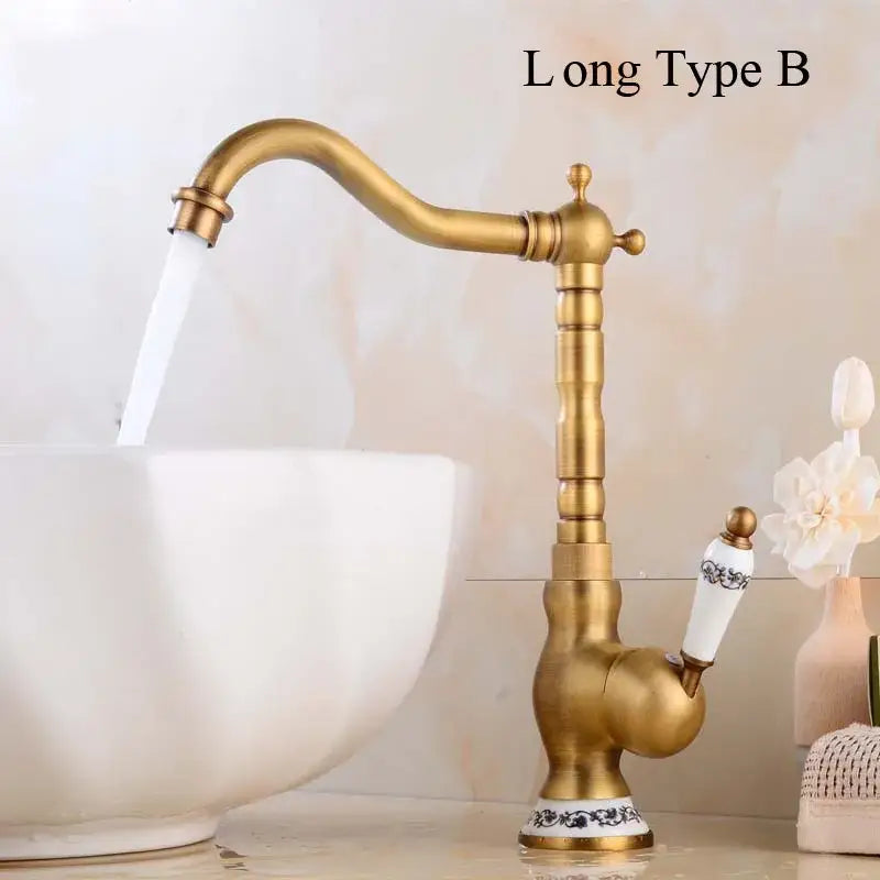 Decorbites antique brass basin faucet with long spout, ornate segmented brass body, and white ceramic handle with floral detailing