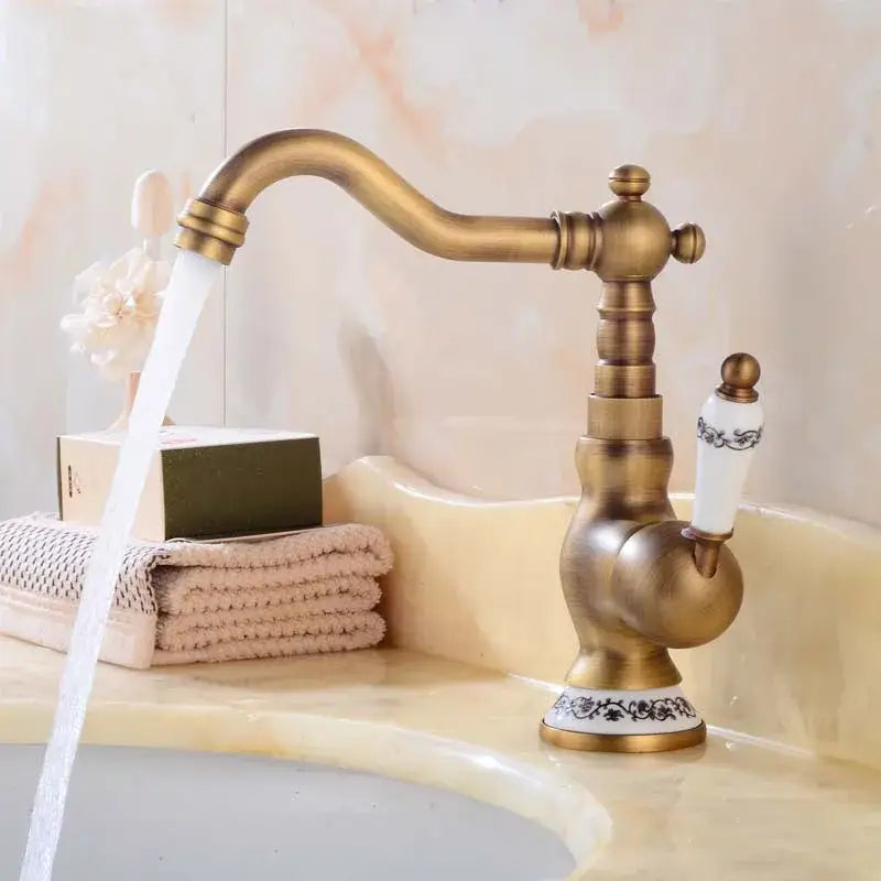 DecorBites antique brass basin faucet with ornate detailing and a white ceramic handle with black floral patterns