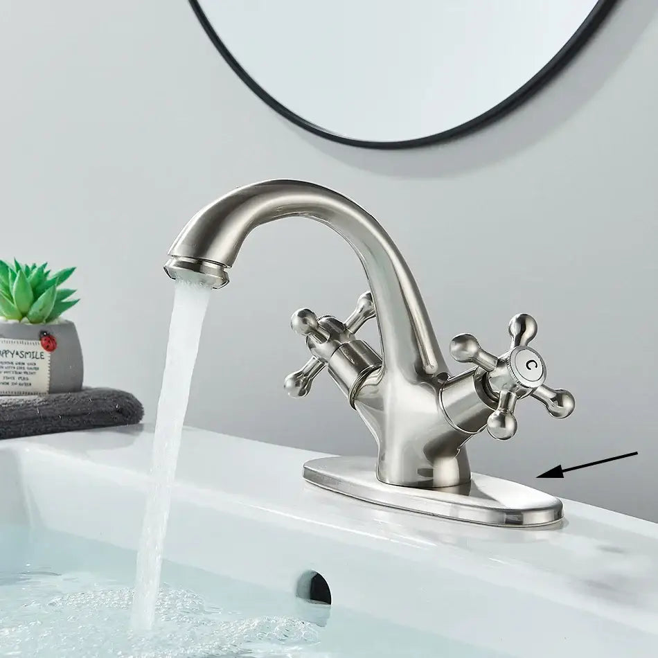 Stainless steel two-handle basin faucet with curved spout and cross handles shown with DecorBites antique brass basin faucet
