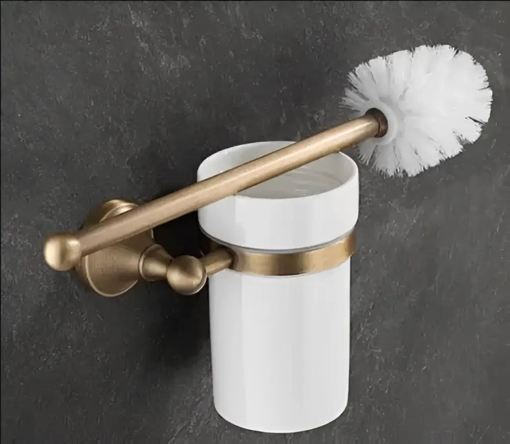 White ceramic toilet brush holder with antique brass bathroom accessory bracket holding white bristle brush in set