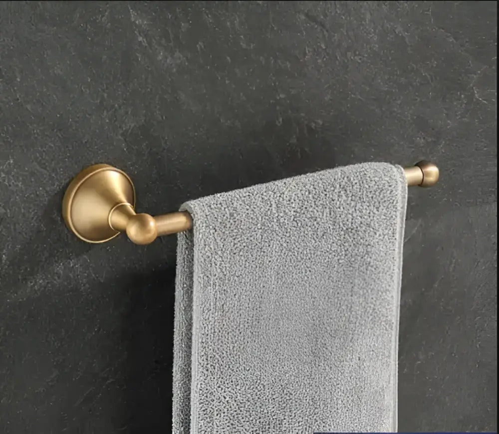 Brass towel rack holding gray textured towel in decorbites antique brass bathroom accessory set