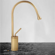 Brass bathroom basin faucet with antique brass finish, sleek curved spout, and cylindrical base for bathroom use