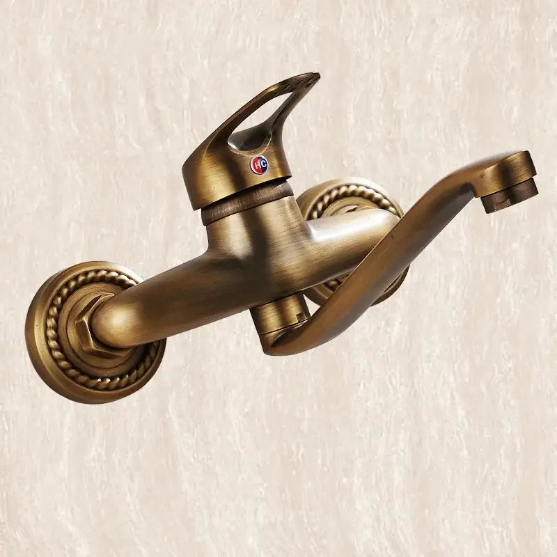 DecorBites antique brass bathroom basin faucet with ornate rope-textured bases and a sleek curved long spout wall mount