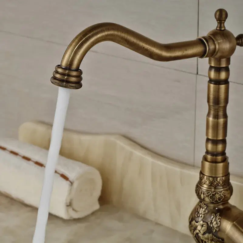 Decorbites™ antique brass bathroom sink faucet mixer with ornate floral detailing and curved spout for hot cold water