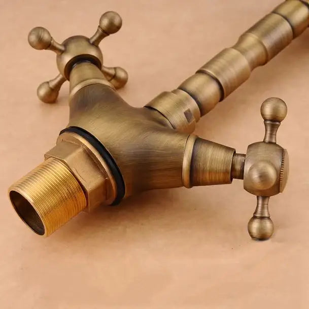 DecorBites antique brass double cross handle basin faucet with ornate segmented spout and 360 degree swivel feature
