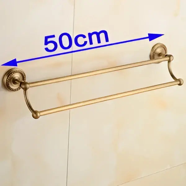 Brass double-tier antique brass towel bar rack with ornate curved ends and decorative wall mounts by DecorBites