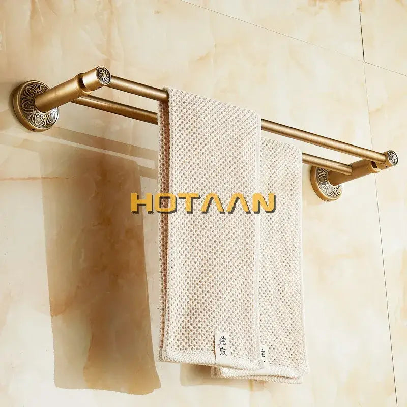Decorbites antique brass double towel bar made of solid aluminium with ornate end caps holding two off-white mesh towels