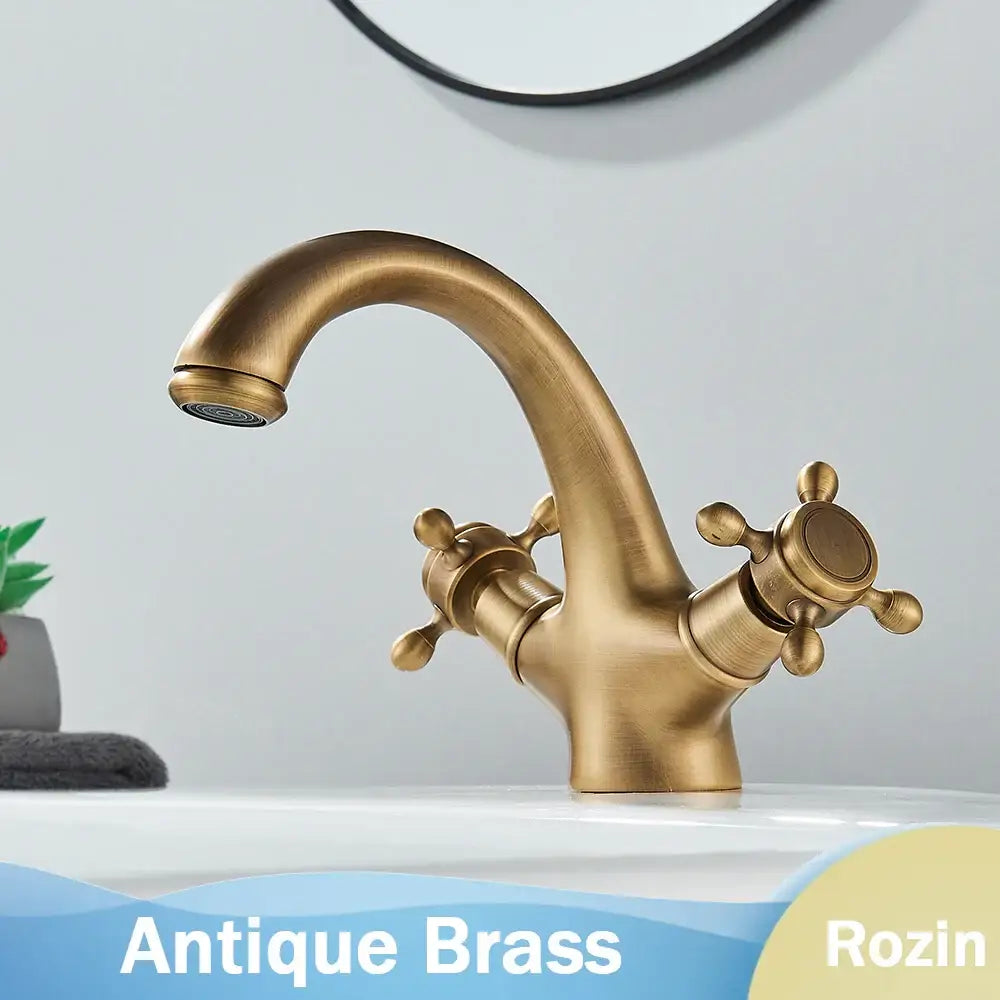 Antique brass dual handle basin faucet with cross-shaped handles and curved spout for bathroom deck mounting
