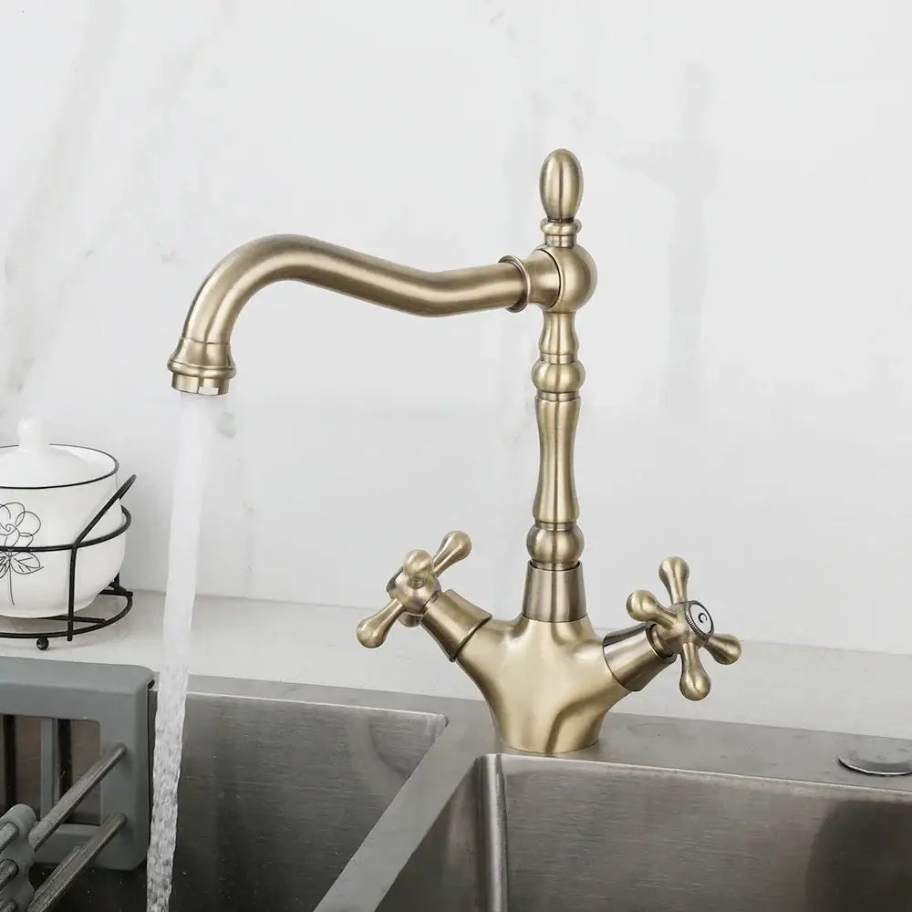 Antique brass dual handle DecorBites swivel sink faucet with ornate cross handles and curved spout in farmhouse style
