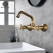 DecorBites™ antique brass dual handle kitchen faucet with ornate cross handles and curved spout wall mounted design