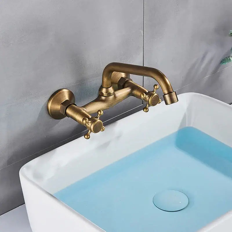 Decorbites antique brass dual handle wall mount kitchen faucet with ornate cross-shaped knobs in brass finish