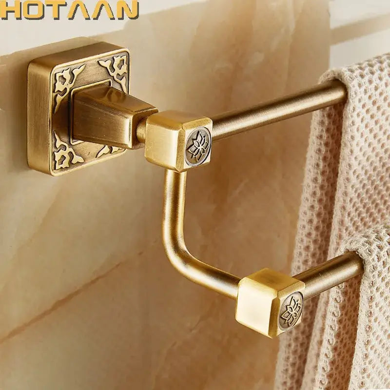 Decorbites antique brass finish double towel bar with gold-colored brass, ornate square mounts, and floral engravings